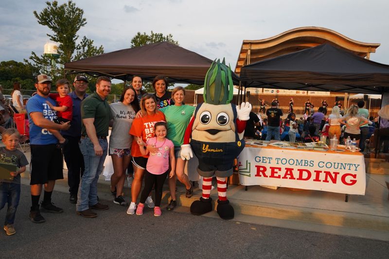 Families at a festival booth with the Vidalia onion mascot